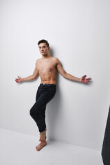 Fototapeta premium sexy guy in jeans stands barefoot on the floor indoor