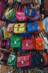 Multicolored leather bags on the street counter of the city market