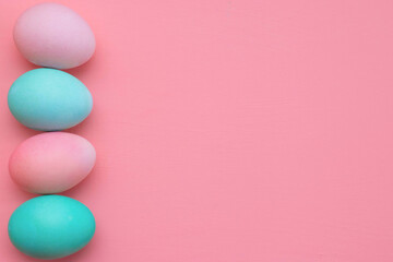 Easter decor in pastel colors: turquoise and pink eggs on a pink background, copy space. The photo