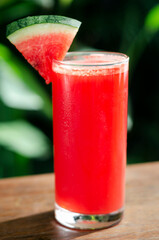 glass of fresh organic watermelon juice on table outdoors