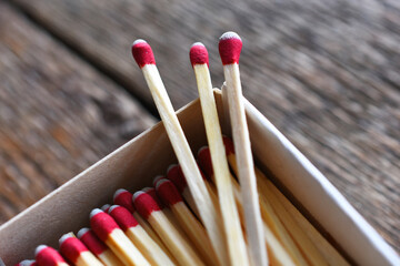 A close up image of a several wooden matches on a wooden background. 
