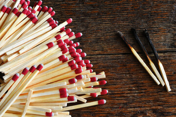 A close up image of a several wooden matches on a wooden background. 