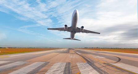 Fototapeta na wymiar White Passenger plane fly up over take-off runway from airport 