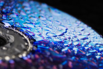 Compact Disc CD with water drops  and shiny colorful reflection . Abstract background