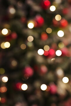 Colorful red, yellow and green Christmas tree bokeh background of de focused glittering lights