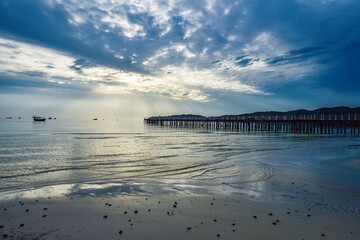 beautiful landscape of the blue sky, wooden boat, wooden bridgeon the Kohrong Samloem beach at Cambodia