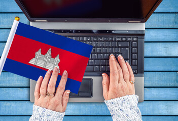 woman hands and flag of Cambodia on computer, laptop keyboard 