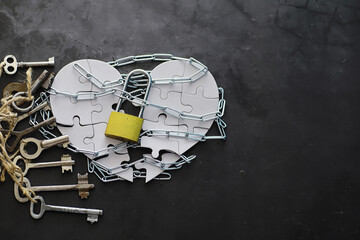 White heart-shaped puzzle. Heart affairs. Undivided love. Broken heart. The key to the heart. Closed heart on a lock. Concept of love.