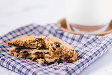 Chocolate cookies on napkin and blur glass of milk background on marble table