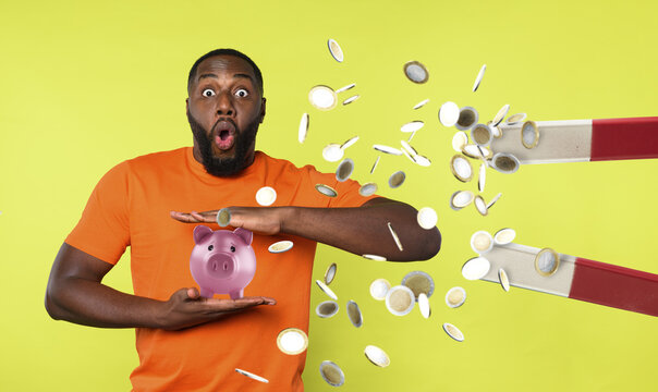 Man tries to protect his piggybank from a big magnet that ruba steals money. concept of money fraud and theft. Green background