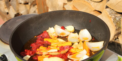 Onions and carrots are sautéed in a pan with tomato paste