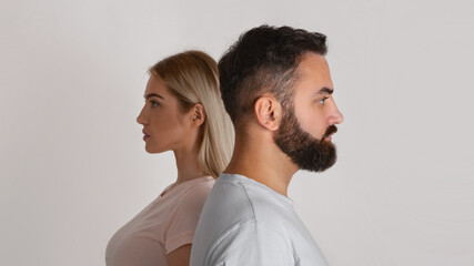 Gender equality and diverging views. Serious man and woman look in different directions