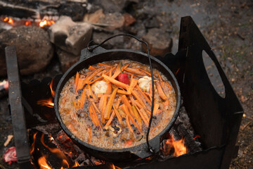 pilaf is a traditional Uzbek dish. rice with chickpeas, vegetables and meat. cauldron with pilaf is...