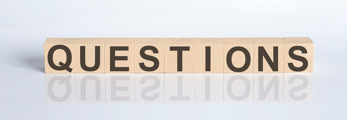 QUESTIONS word from wooden blocks on the white desk