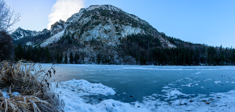 Gefrorener Bergsee im Chiemgau vor Bergen mit Schnee