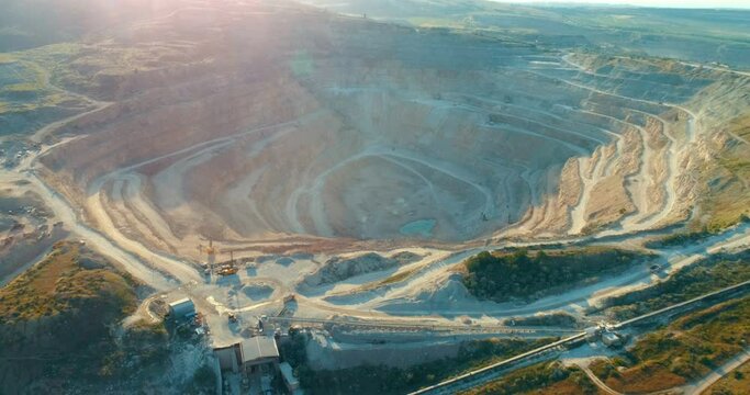 Aerial view of opencast mining quarry with lots of machinery at work - view from above. 