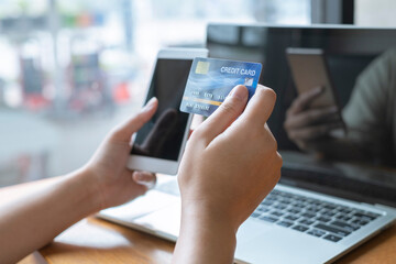 Women with credit cards and using mobile phones to shop online.