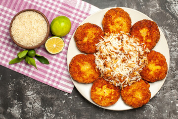 top view tasty fried cutlets with cooked rice on the dark background rissole meat food