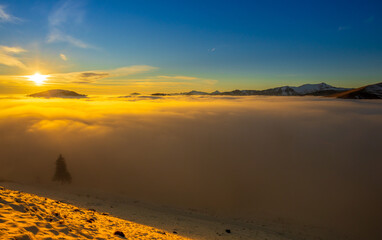 Beautiful sunset over sea of clouds. Winter landscape