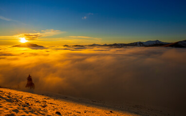 Beautiful sunset over sea of clouds. Winter landscape