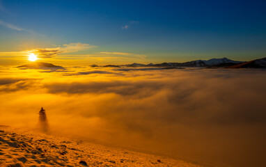 Beautiful sunset over sea of clouds. Winter landscape