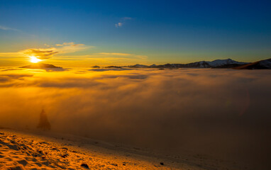 Beautiful sunset over sea of clouds. Winter landscape