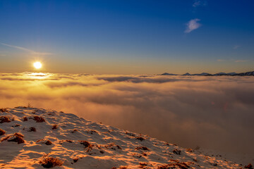 Beautiful sunset over sea of clouds. Winter landscape