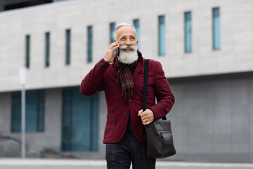 Fototapeta premium Stylish senior man talking on phone, comming back from office