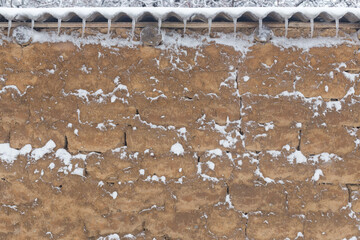 Beautiful old wall with cracks and texture in winter and snow