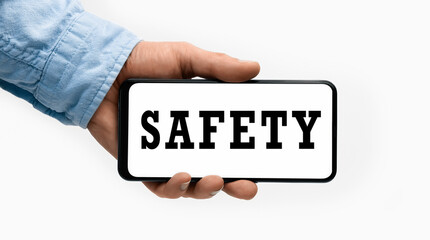 Closeup of a male hand holding Smartphone with word Safety on display