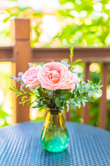 Beautiful flower in vase on table with garden view