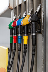 Pistols with different types of fuel at the gas station. Vertical.