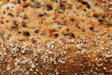 The surface of freshly baked grain bread. Close-up. Background. Space for text. Healthy eating.