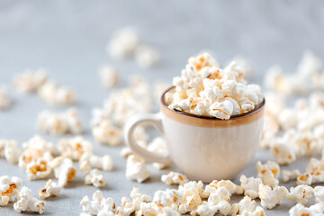 Homemade popcorn in a wooden bowl on a grey background