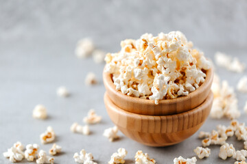 Homemade popcorn in a wooden bowl on a grey background
