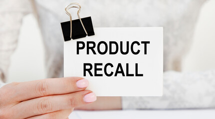The girl holds a card with a PRODUCT RECALL tact.