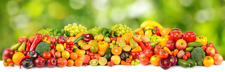 Wide pattern of ripe and fresh fruits and vegetables on green background.