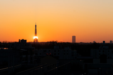 Le soleil grimpe sur la structure de la tour Eiffel afin de se hisser dans le ciel