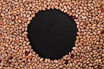 Coloren beans on black stone background.