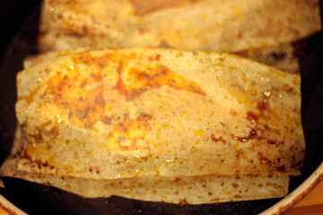 Chicken roasted in paper on black pan