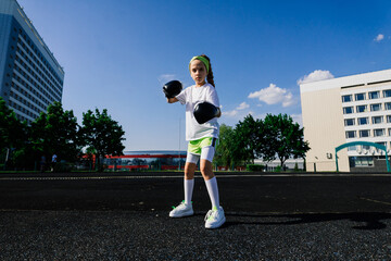 Female child boxer in gloves, feminism concept. Back to school, physical training lesson.