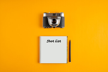 Vintage camera with a notebook with the words shot list written against yellow background.