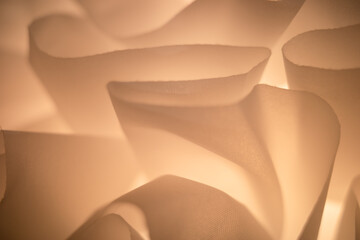 Closeup of mesh cloth in spiral shape, warm light as background