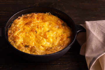 Frittata with cheese, mozzarella and stewed pumpkin in a cast iron pan on a wooden background