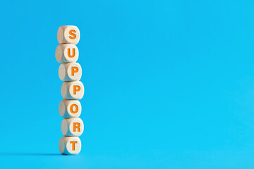 The word support on tiered wooden cubes against blue background.