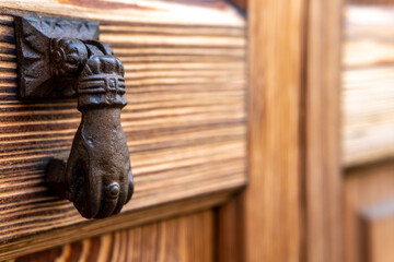 Close-up of an antique iron knob on an antique wooden door