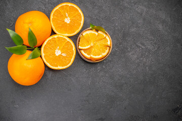 Overhead view of set of yellow whole and chopped lemons on dark background