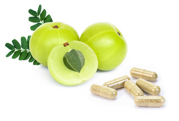Indian gooseberry fruits or Amla ( phyllanthus emblica ) with green leaves and powder capsules on white background. 
