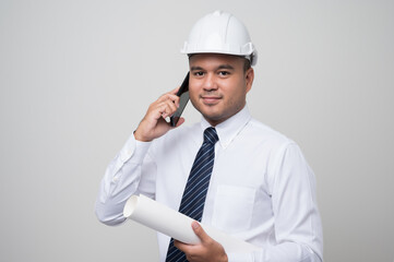 Asian engineer talking with customer on phone to home service. Worker wearing hard hat using smartphone standing on isolated white background.