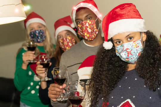 Friends Drinking Wine Wearing Protective Face Mask At The House For Coronavirus In Christmas Time. Family Having Fun In A House Drinking Red Wine With The Face Mask Avoid Covid 19.